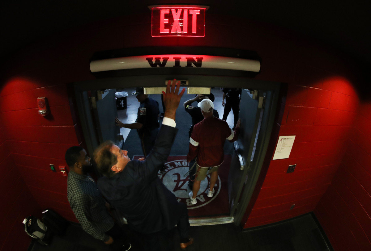 Nick Saban hits the Alabama "Win" bar above the locker room door